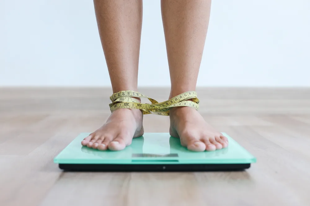 close-up-legs-on-weigh-scales-2026-01-09-06-28-35-utc (1) 猛健樂是什麼?揭秘成分、效果與副作用。減重減脂期間這樣使用,不掉肌肉不復胖